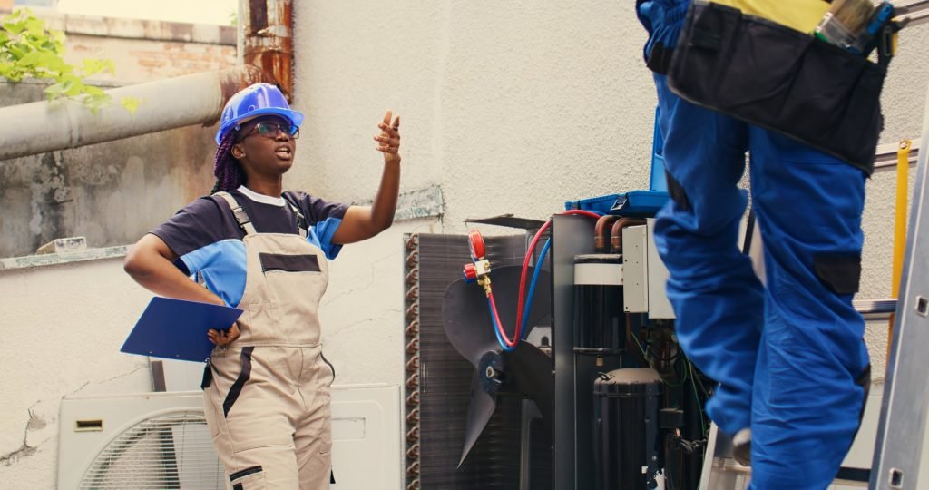 HVAC workers repairing an air conditioning system in an urban setting